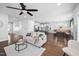 Open-concept living room showcasing hardwood floors, a ceiling fan, and seamless flow to the kitchen at 2404 Glade Mill Ct, Fuquay Varina, NC 27526