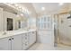 Bright bathroom featuring a double sink vanity, a shower and a soaking tub under a window at 2428 Havershire Dr, Raleigh, NC 27613