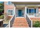 Charming front porch with brick steps, white columns, and a turquoise front door at 2428 Havershire Dr, Raleigh, NC 27613