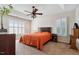 Inviting main bedroom with a ceiling fan, two windows and dresser with a plant at 2428 Havershire Dr, Raleigh, NC 27613
