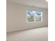 Bright bedroom with neutral carpet and a window offering a view of the neighborhood at 265 Umstead St, Sanford, NC 27330