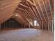 Unfinished attic showing exposed rafters and a window with natural light at 273 Homestead Way, Clayton, NC 27527