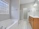 Well-lit bathroom features a soaking tub, window and double vanity with wooden cabinets at 273 Homestead Way, Clayton, NC 27527