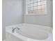 Bright bathroom features a white tub and a glass block window at 273 Homestead Way, Clayton, NC 27527