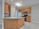 Updated kitchen featuring wood cabinets, a peninsula counter, and convenient access to appliances at 273 Homestead Way, Clayton, NC 27527