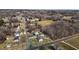 Aerial view of a home with surrounding trees, roads, and expansive open field at 3307 Altamahaw Church St, Elon, NC 27244