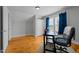 Bright bedroom with hardwood floors, featuring a desk, chair, and two large windows with natural light at 3307 Altamahaw Church St, Elon, NC 27244