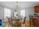 Bright dining room featuring a chandelier, a glass table with metal chairs, and breakfast bar at 3307 Altamahaw Church St, Elon, NC 27244