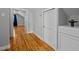 Hallway with hardwood floors, white trim, and doors leading to various rooms, creating seamless flow at 3307 Altamahaw Church St, Elon, NC 27244