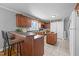 Kitchen featuring brown cabinets, a tile floor, bar top seating, and an island at 3307 Altamahaw Church St, Elon, NC 27244