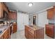 Kitchen featuring wood cabinets, tile floor, white doors, and a kitchen island at 3307 Altamahaw Church St, Elon, NC 27244