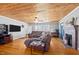 Comfortable living room with hardwood floors, wood ceiling, ceiling fan, and brick fireplace at 3307 Altamahaw Church St, Elon, NC 27244