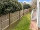 This is a backyard view with a tall privacy fence, green grass and a deck and stairs at 3809 Mardela Spring Dr, Raleigh, NC 27616