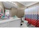 This bathroom has an all-white vanity and an adjoining toilet/shower with colorful shower curtain at 3809 Mardela Spring Dr, Raleigh, NC 27616
