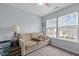 Cozy bedroom features a comfortable sofa, neutral carpet and natural light from large windows at 3809 Mardela Spring Dr, Raleigh, NC 27616