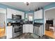 Modern kitchen with stainless appliances, white cabinetry, granite counters and views to the living area at 3809 Mardela Spring Dr, Raleigh, NC 27616