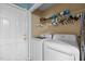 Functional laundry area including a washer, dryer and overhead shelving for efficient storage solutions at 3809 Mardela Spring Dr, Raleigh, NC 27616