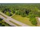 Aerial view of the property featuring the road, lush surroundings, the house, and a peaceful pond at 4200 Us 1 Highway South, Kittrell, NC 27544