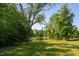 Scenic backyard featuring a lush lawn, mature trees, and a tranquil pond, creating a private oasis at 4200 Us 1 Highway South, Kittrell, NC 27544