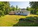 Backyard with a wooden deck, lush lawn, mature trees and a fenced perimeter at 4200 Us 1 Highway South, Kittrell, NC 27544