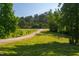 Long gravel driveway winding through a lush green lawn, leading to a secluded home at 4200 Us 1 Highway South, Kittrell, NC 27544