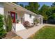 Charming home featuring a vibrant red front door and landscaped entrance with colorful flowers and lush greenery at 4200 Us 1 Highway South, Kittrell, NC 27544