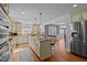 Bright kitchen featuring a center island with seating, stainless steel appliances, and hardwood flooring at 4200 Us 1 Highway South, Kittrell, NC 27544