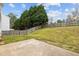 Fenced backyard featuring grass, trees, and a concrete patio at 5332 Seaspray Ln, Raleigh, NC 27610
