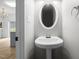 Well-lit half bathroom features a pedestal sink and oval mirror at 5332 Seaspray Ln, Raleigh, NC 27610