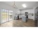 Modern white kitchen featuring a center island, stainless steel appliances, and sliding glass doors at 5332 Seaspray Ln, Raleigh, NC 27610