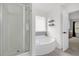 Spa-like main bathroom showcasing a shower, a soaking tub, and modern gray and white finishes at 5332 Seaspray Ln, Raleigh, NC 27610