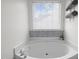 Elegant soaking tub is featured in the main bathroom with modern fixtures and a tiled backsplash at 5332 Seaspray Ln, Raleigh, NC 27610
