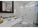 Bright bathroom featuring a white vanity, tiled shower, and decorative mirror at 5504 Quails Call Ct, Garner, NC 27529