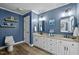 Bright bathroom with double sinks, white cabinets, and blue walls at 5504 Quails Call Ct, Garner, NC 27529