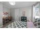 Well-lit bedroom featuring a desk, display cabinet, and grey patterned bedspread at 5504 Quails Call Ct, Garner, NC 27529