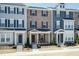 Exterior shot of townhomes with varying color schemes, each with a front porch and landscaping at 5917 Kayton St, Raleigh, NC 27616