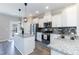 Modern kitchen with stainless steel appliances, granite countertops, and a center island at 5917 Kayton St, Raleigh, NC 27616