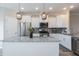 Modern kitchen features white cabinets, granite countertops, stainless steel appliances, and pendant lighting at 5917 Kayton St, Raleigh, NC 27616
