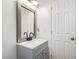 Bathroom vanity featuring a silver trimmed mirror, dark faucet and handles, with a gray cabinet at 608 N 15Th St, Erwin, NC 28339