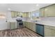 Charming kitchen featuring light green cabinets, stainless steel appliances, and wood-look floors at 608 N 15Th St, Erwin, NC 28339