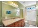 Well-lit bathroom with a granite countertop, shower with white tile, and green painted walls at 611 S Buchanan Blvd, Durham, NC 27701