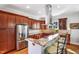 A well-lit gourmet kitchen features granite countertops, a stainless refrigerator, seating for three, and stainless range hood at 611 S Buchanan Blvd, Durham, NC 27701