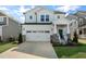 Charming two-story home with stone accents, a well-manicured lawn, and a two-car garage at 625 Sage Oak Ln, Holly Springs, NC 27540