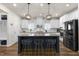 Modern kitchen featuring a large island with bar seating and stylish lighting fixtures at 625 Sage Oak Ln, Holly Springs, NC 27540