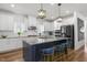 Modern kitchen with white cabinets, a navy island with bar stools, and stainless steel appliances at 625 Sage Oak Ln, Holly Springs, NC 27540