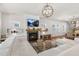 Bright living room featuring a cozy fireplace, modern lighting, and a comfortable white sectional at 625 Sage Oak Ln, Holly Springs, NC 27540