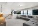 Large sectional and neutral carpet in the living room with views from the windows at 625 Sage Oak Ln, Holly Springs, NC 27540