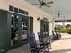 Outdoor porch with black rocking chairs, ceiling fans, and french doors with adjacent dark green shutters at 625 Sage Oak Ln, Holly Springs, NC 27540
