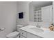 Bright bathroom with a white vanity, mirror, toilet, and shower featuring a gray curtain at 63 Pale Moss Dr, Clayton, NC 27527