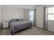 Bright bedroom featuring plush carpet, neutral walls, and two windows with decorative curtains at 63 Pale Moss Dr, Clayton, NC 27527